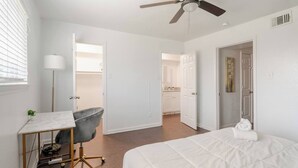 A bedroom with a bed, desk, chair, and a ceiling fan. - Pink 1BHK, 5 miles from Downtown + Free Parking (Houston)