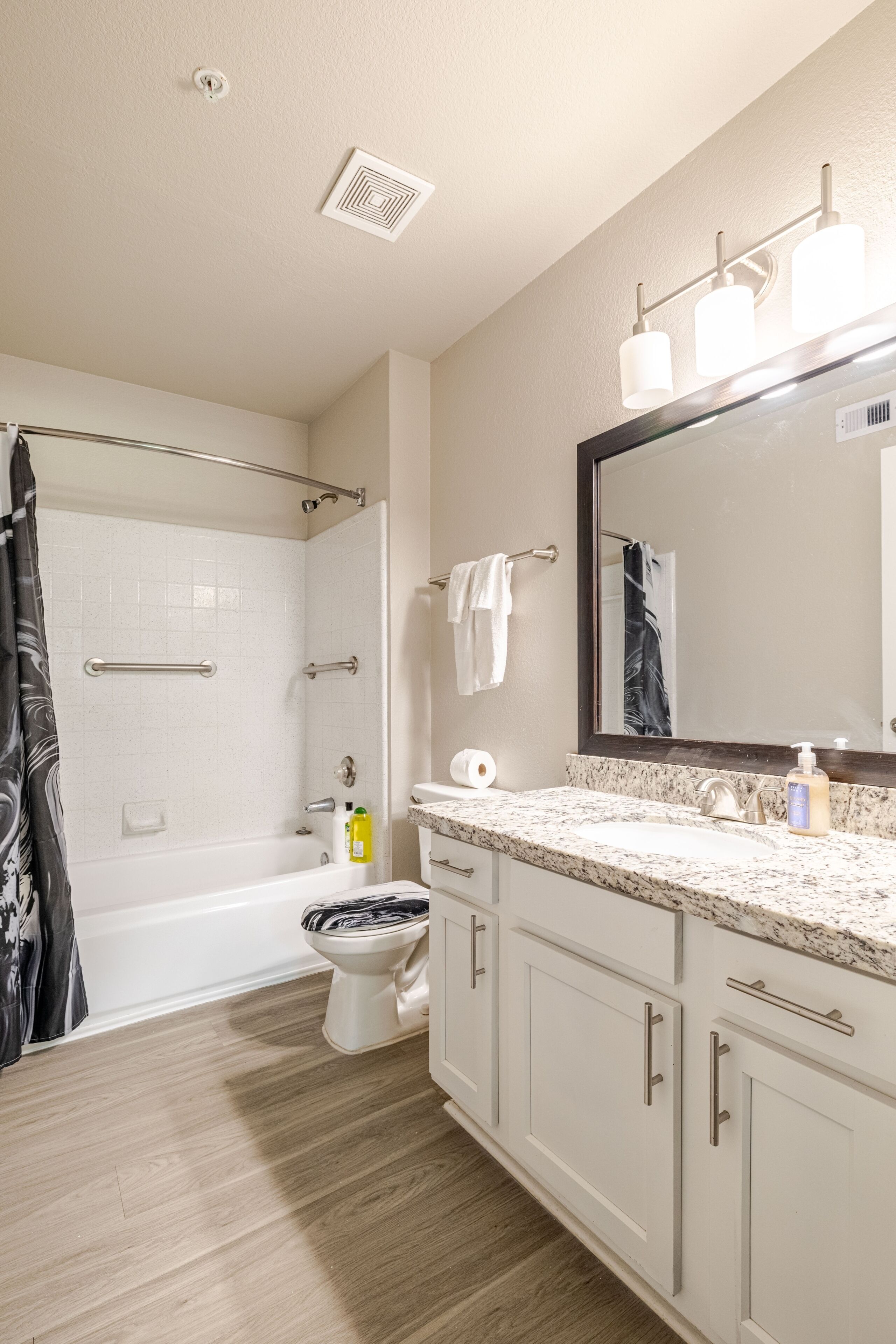 Un baño moderno con bañera, inodoro y zona de ducha.
