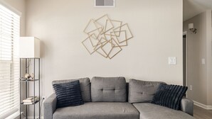 Ein Wohnzimmer mit einem Ecksofa, einer Wandleuchte und einer Heizung.