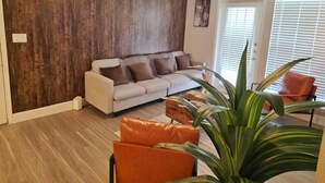 A living room with a sofa, a coffee table, and a plant. - Charming 3Bed 2Bath apt in front of NRG & near TMC (Houston)