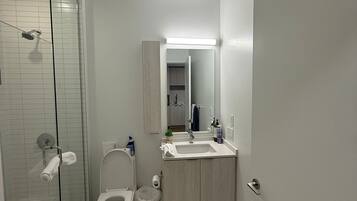 Een douche, handdoeken, zeep, toiletpapier