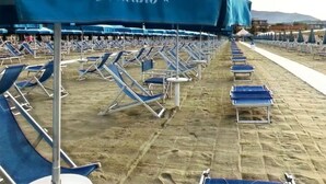 A beach with rows of blue lounge chairs and a large blue umbrella labeled "Netto". - Cozy Rustico for 6/7 people with umbrella in Lido di Camaiore (Camaiore)