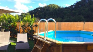 A wooden swimming pool with a ladder, surrounded by a wooden fence and greenery. - Cozy Rustico for 6/7 people with umbrella in Lido di Camaiore (Camaiore)