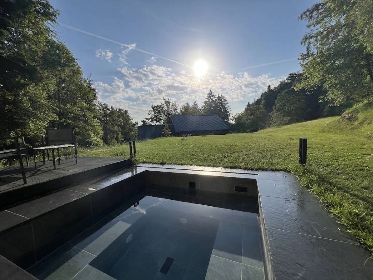 Une piscine offrant une vue dégagée sur le ciel et la végétation environnante.
