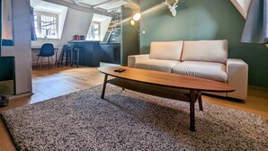 Un salón acogedor con un sofá, una mesa de centro y una zona de cocina al fondo.
