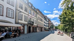 Calle pavimentada con edificios a un lado y acera al otro.