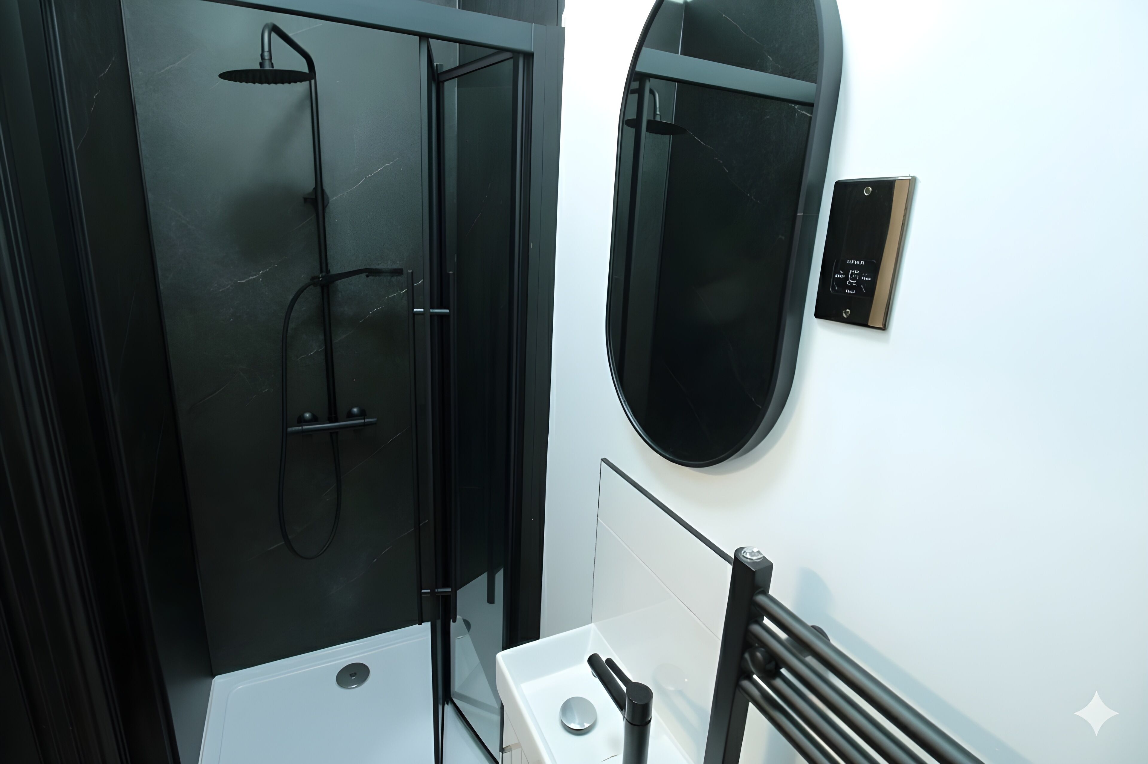 A modern bathroom with a glass-enclosed shower, a white sink, and a black towel rack.