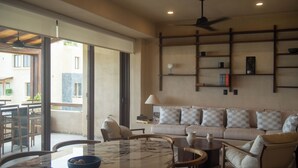 A spacious living area with a large window, a sofa set, a coffee table, and a ceiling fan. - Minimalist elegance by the beach (Zihuatanejo)