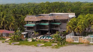 Een resort met meerdere gebouwen, een zwembad en weelderige begroeiing.