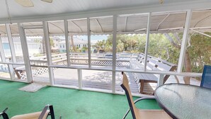 A covered outdoor area with a view of a street and buildings. - Beach Nugget by Tybee Vacation Rentals (Tybee Island)