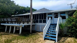 A house with a covered porch, a staircase, and a fenced deck area. - Beach Nugget by Tybee Vacation Rentals (Tybee Island)