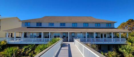 A two-story building with a covered walkway and outdoor seating.