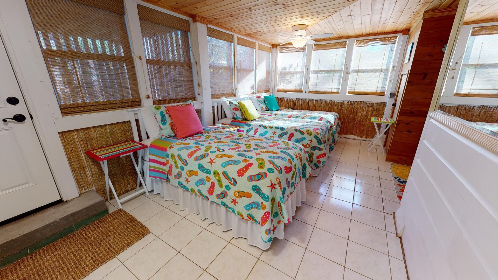 A room with two beds, a small table, and a door.