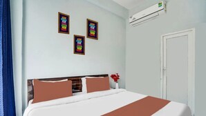 A hotel room with a bed, a wall-mounted air conditioner, and three motivational posters. - Urban Nest Rooms & Rooftop Restaurant (Noida)