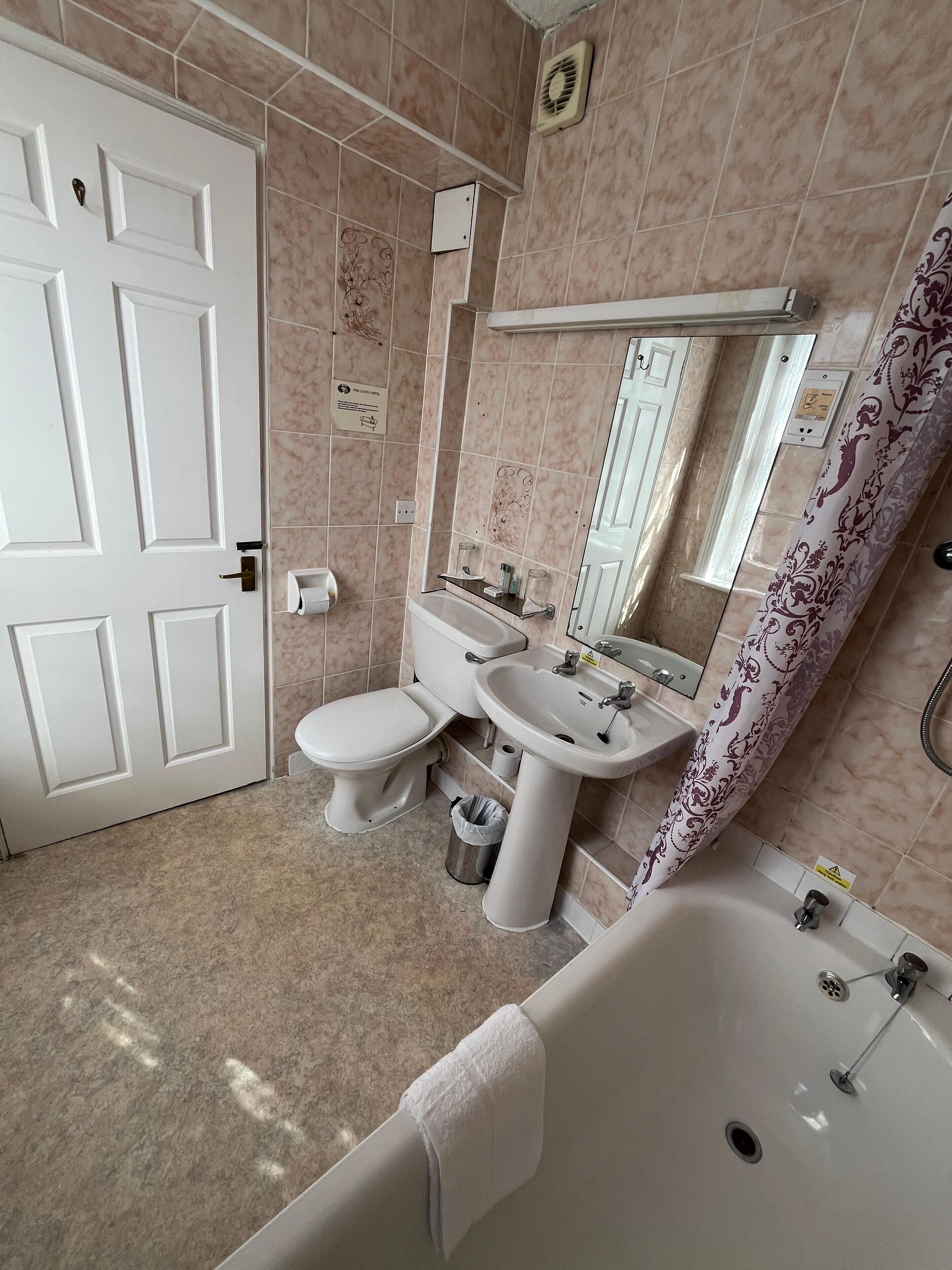 A bathroom with a toilet, sink, and bathtub.
