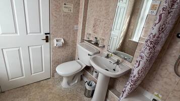 A bathroom with a toilet, sink, and bathtub.