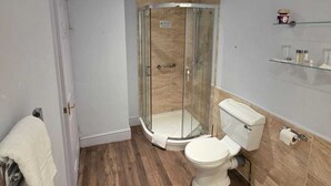 Un baño moderno con ducha de vidrio, inodoro y lavamanos.