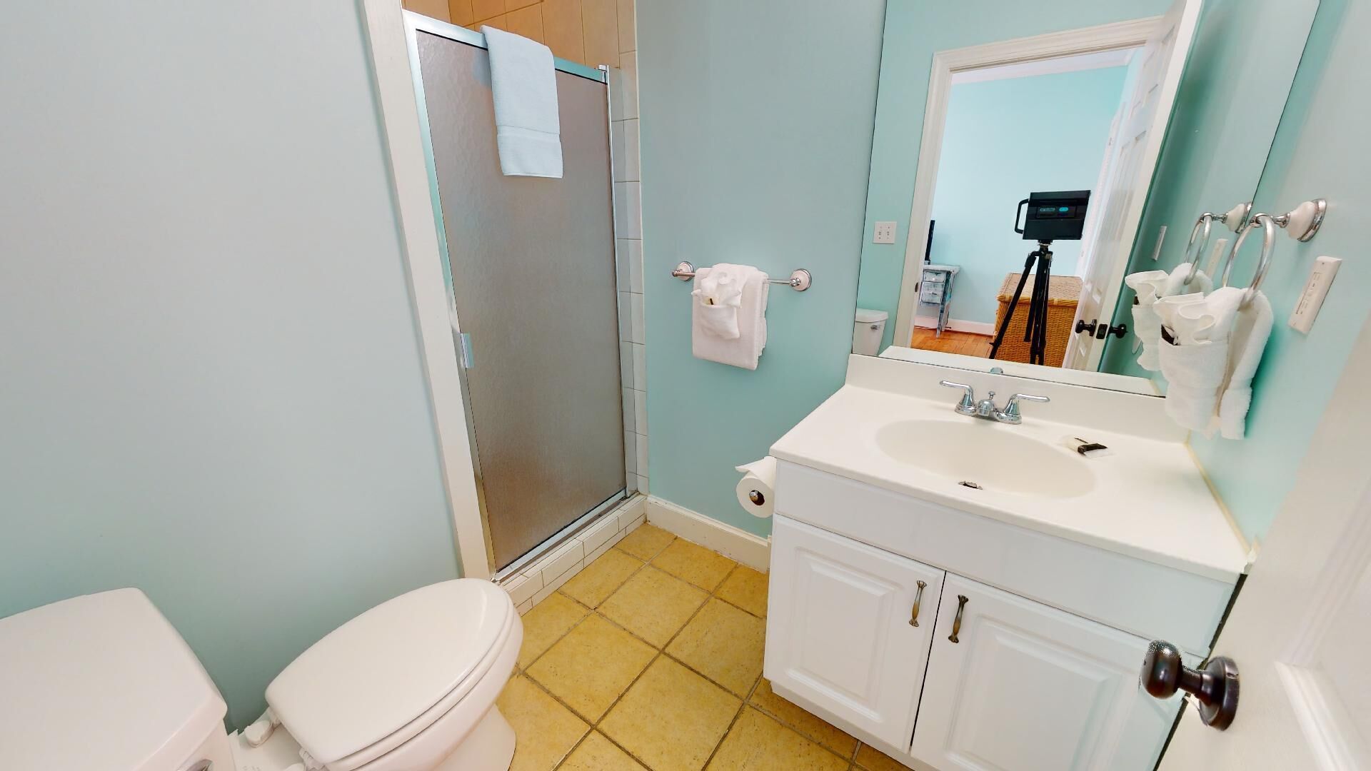 A bathroom with a toilet, sink, and mirror.