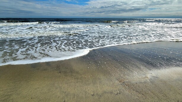 Une plage où les vagues se brisent près du rivage.