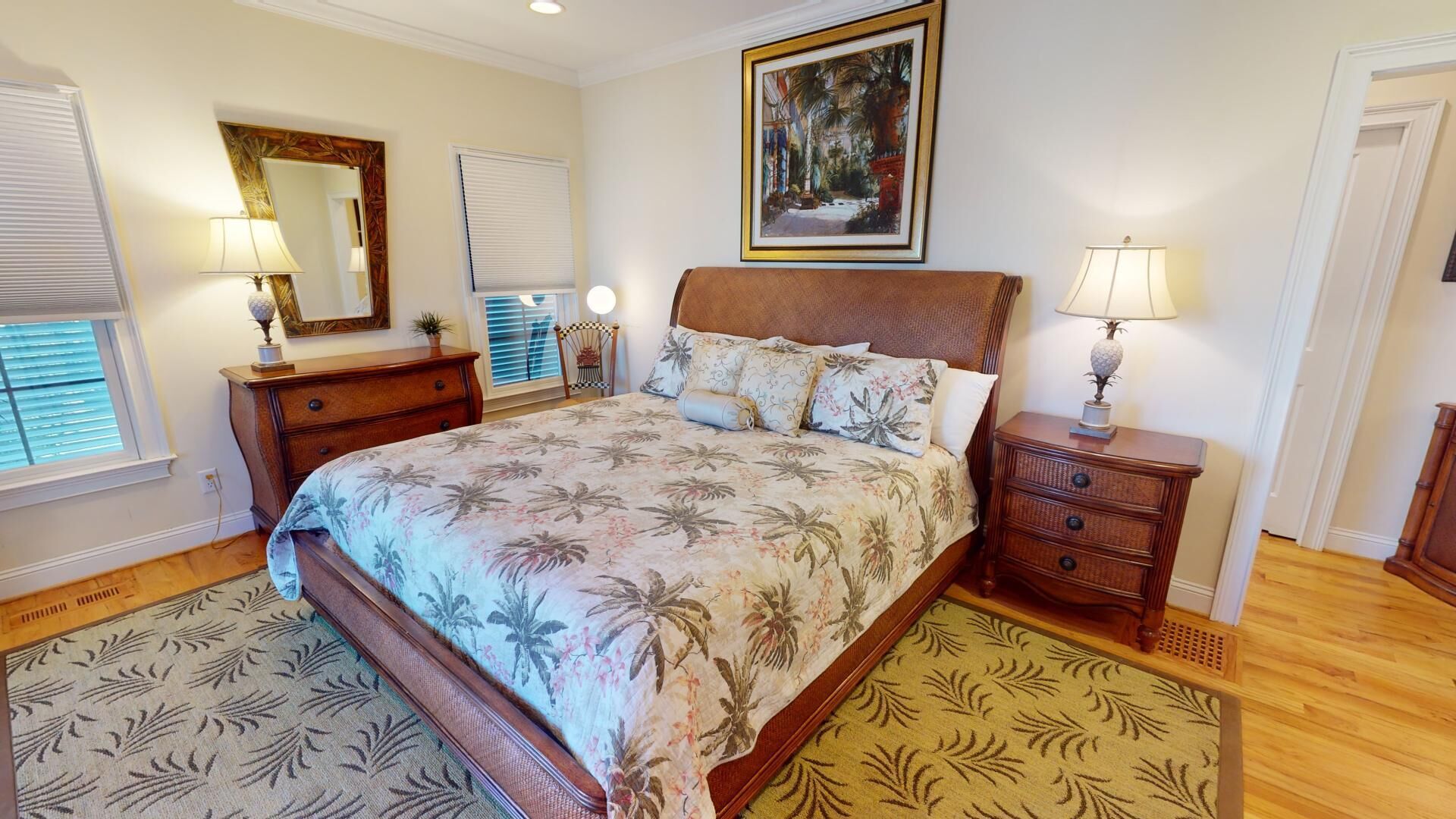 A bedroom with a bed, a nightstand, a dresser, a chair, a window with blinds, and a painting on the wall.