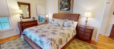 A bedroom with a bed, a nightstand, a dresser, a chair, a window with blinds, and a painting on the wall.