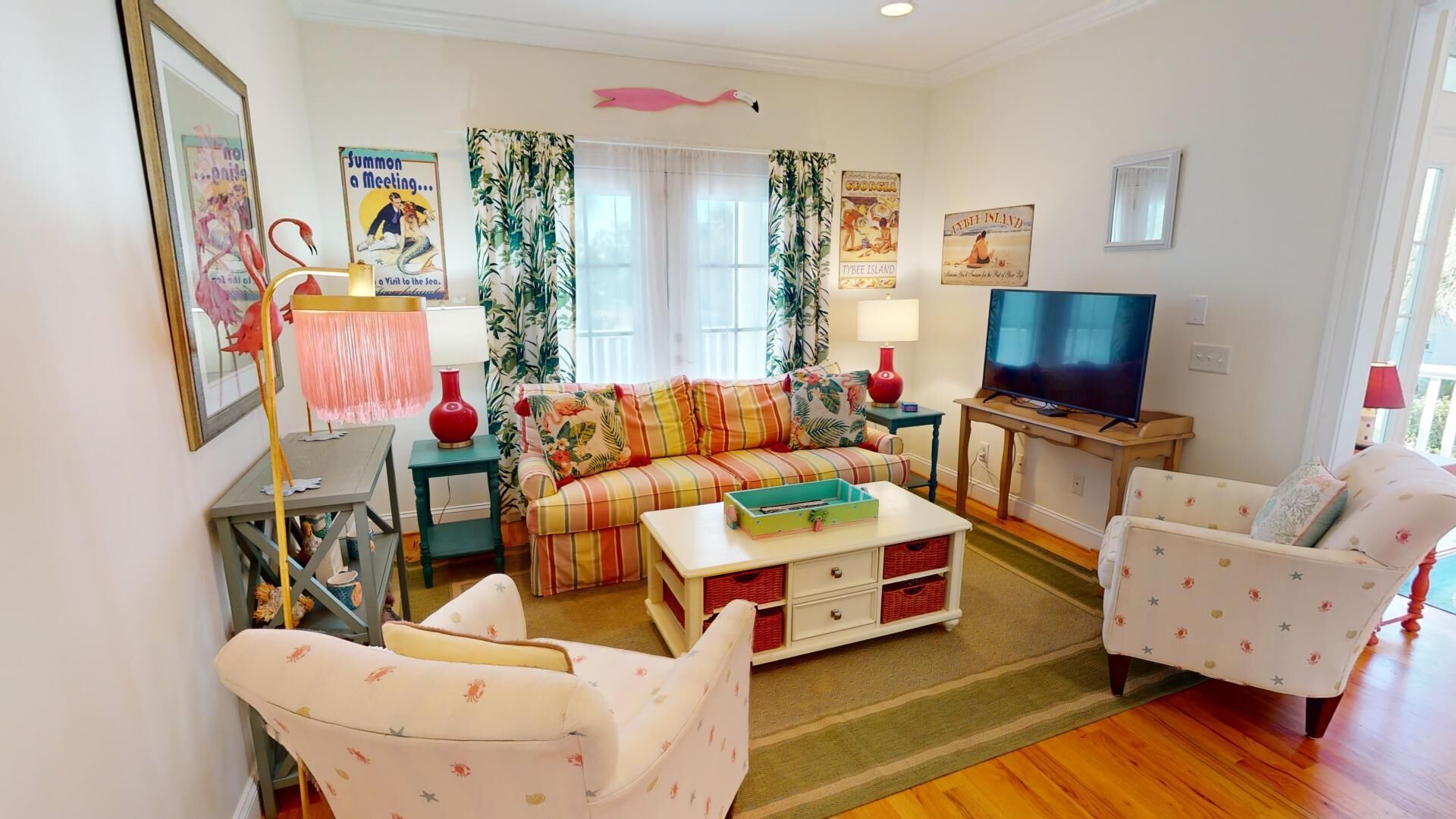 Una sala de estar con un sofá, dos sillones, una mesa de centro, un televisor y una estantería.