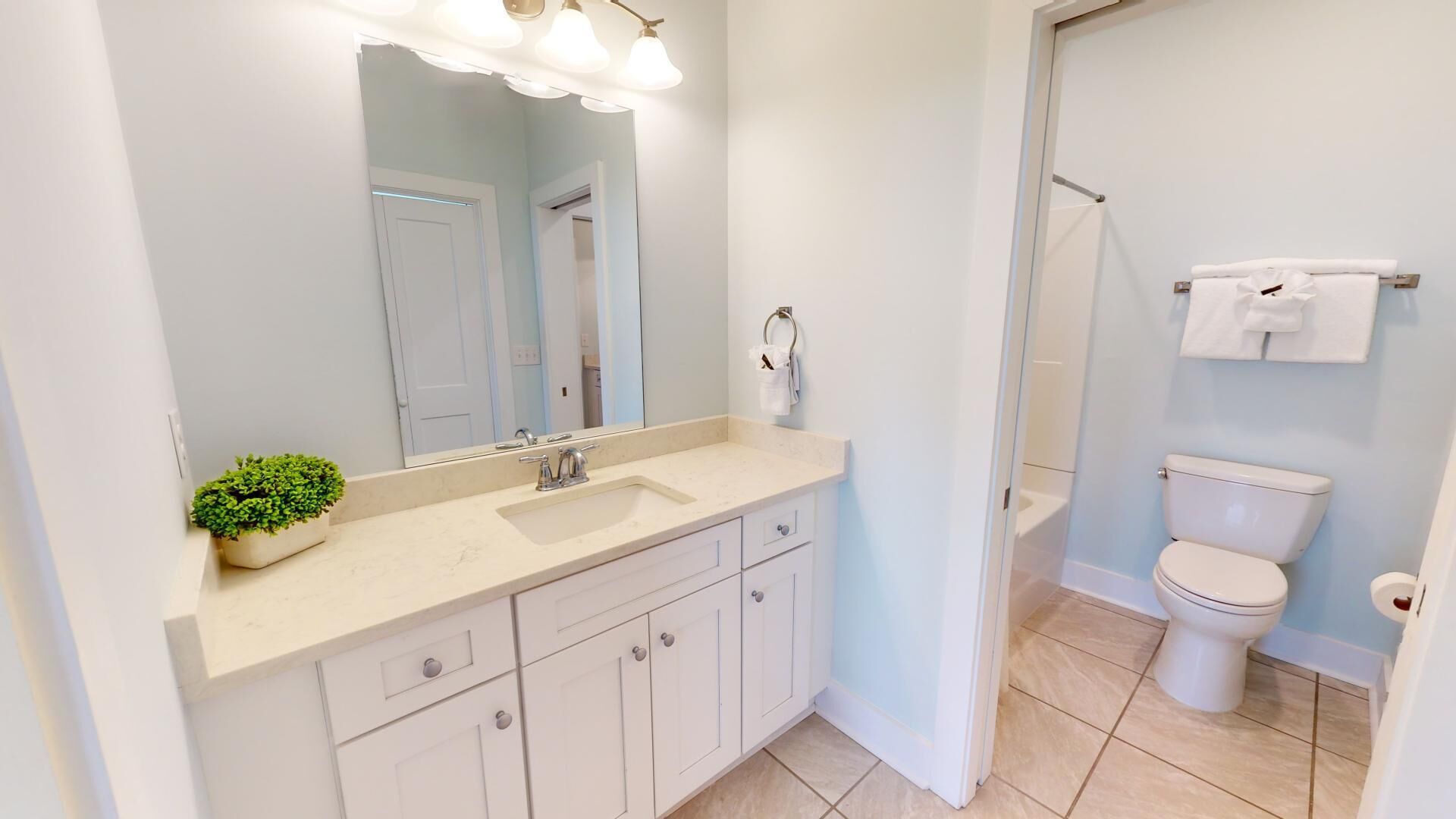 A modern bathroom with a sink, mirror, and toilet.