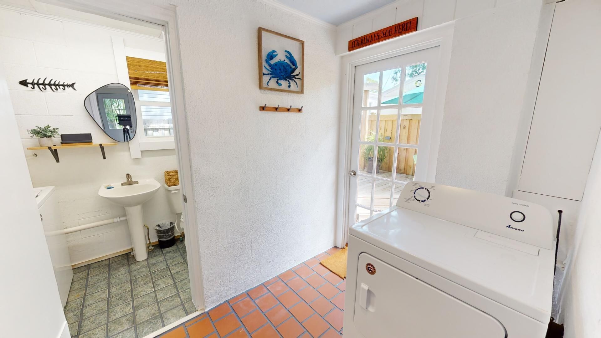 A compact kitchen with a sink, a small window, and a washing machine.