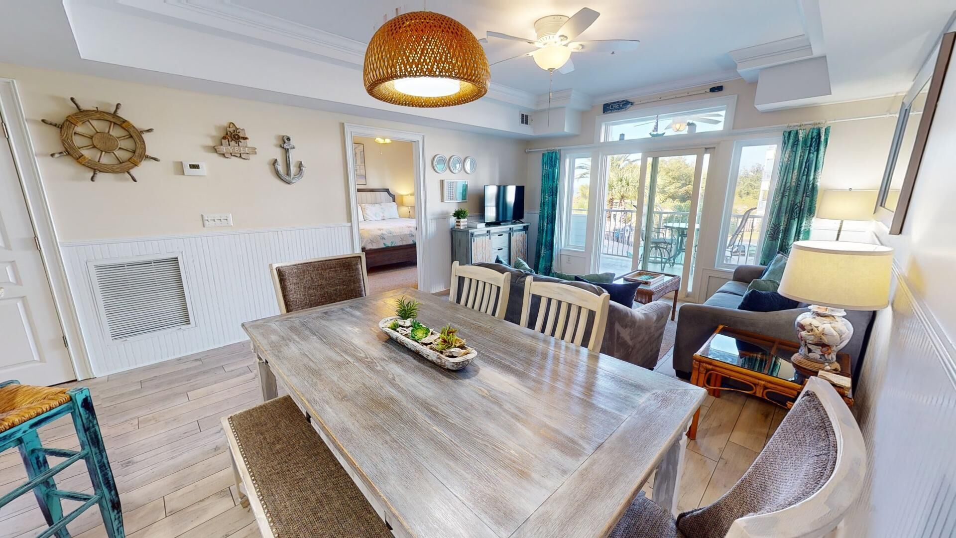 A spacious living area with a wooden dining table, comfortable seating, a television, and a view of the outdoors.