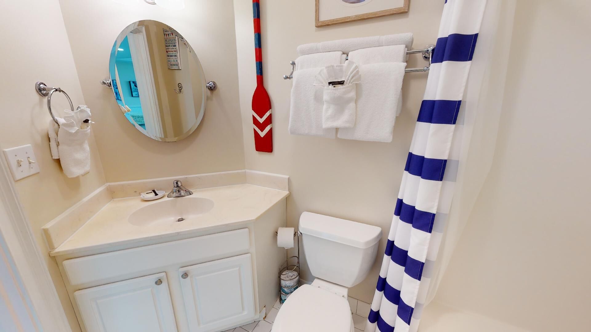 A bathroom with a sink, mirror, toilet, and a shower curtain.