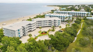 Un hôtel en bord de mer, composé de plusieurs bâtiments, avec une plage et une vue dégagée sur l’océan.