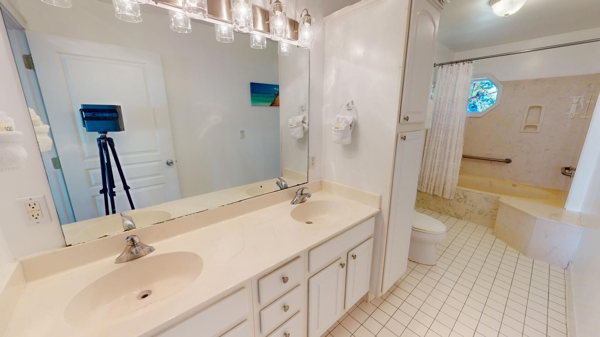 Une salle de bain avec deux lavabos, un grand miroir et un espace douche.