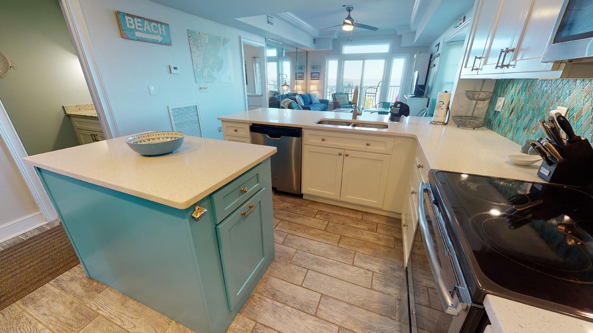 A kitchen with a central island, a dishwasher, and a stove.