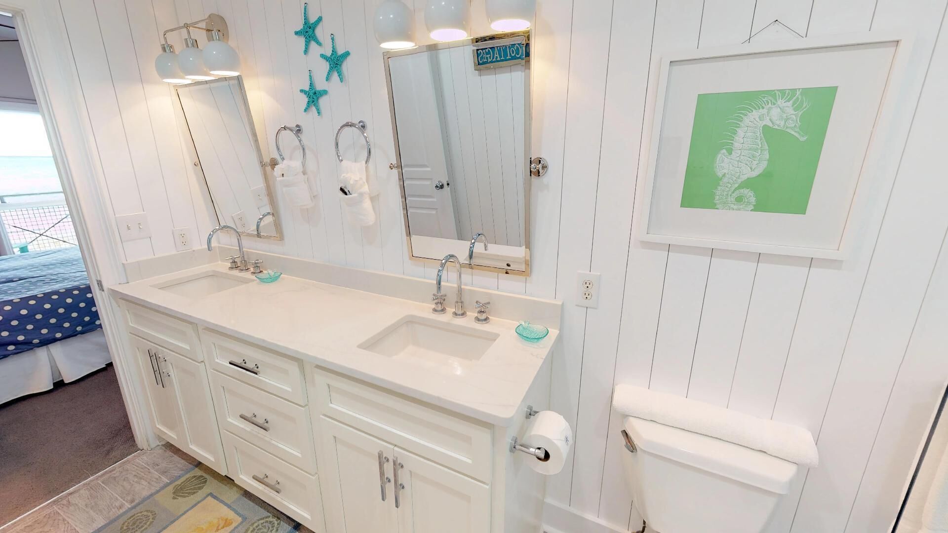 A bathroom with a white vanity, two sinks, a toilet, and a mirror.