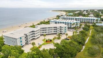 A coastal hotel with multiple buildings, a beach, and a clear view of the ocean.