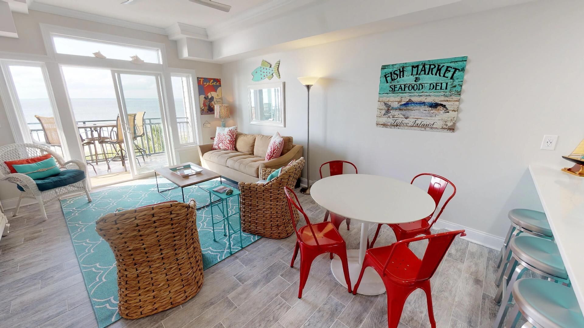 A spacious living area with a sofa, red chairs, a dining table, and a view to the outside.