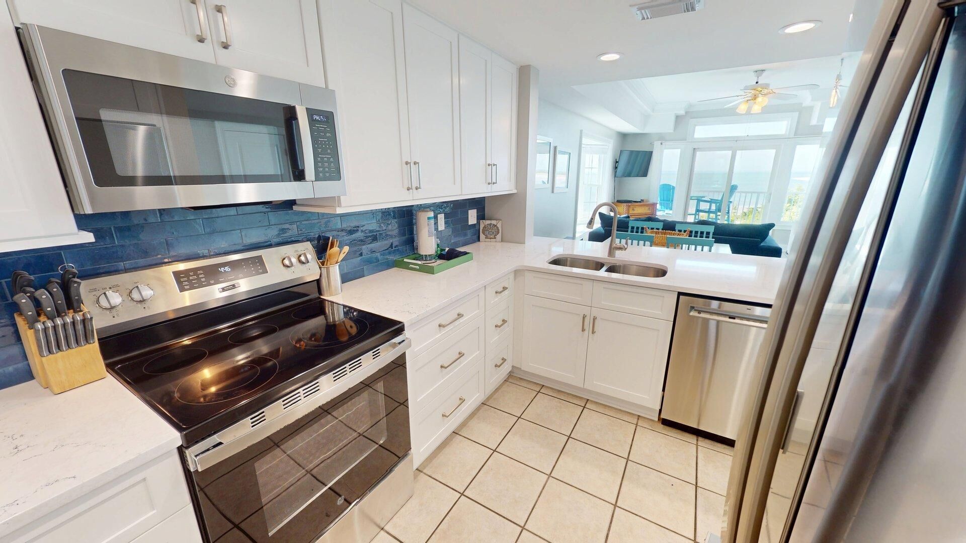 A modern kitchen with white cabinets, a stainless steel microwave, a black stove, and a dishwasher.