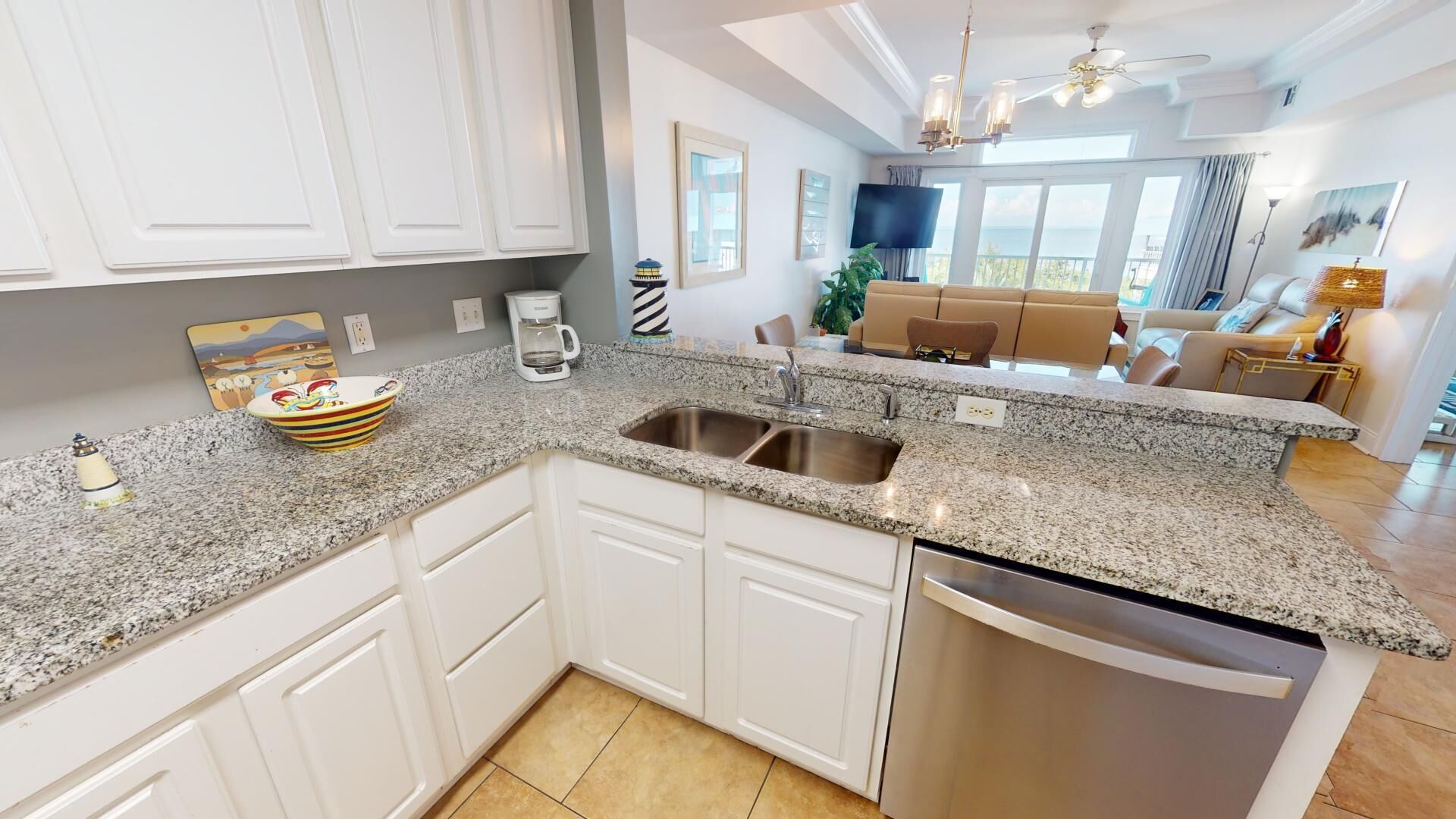 A modern kitchen with white cabinets, granite countertops, and a stainless steel dishwasher.