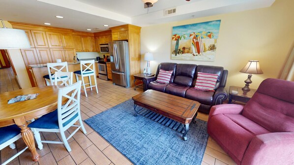A spacious living area with a dining table, chairs, a sofa, and a coffee table.