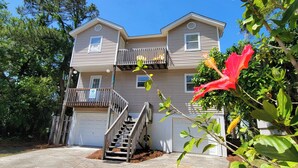 A two-story house with a front porch, a small balcony, and a garage. - Beachy Keen Tybee Vacation Rentals (Tybee Island)