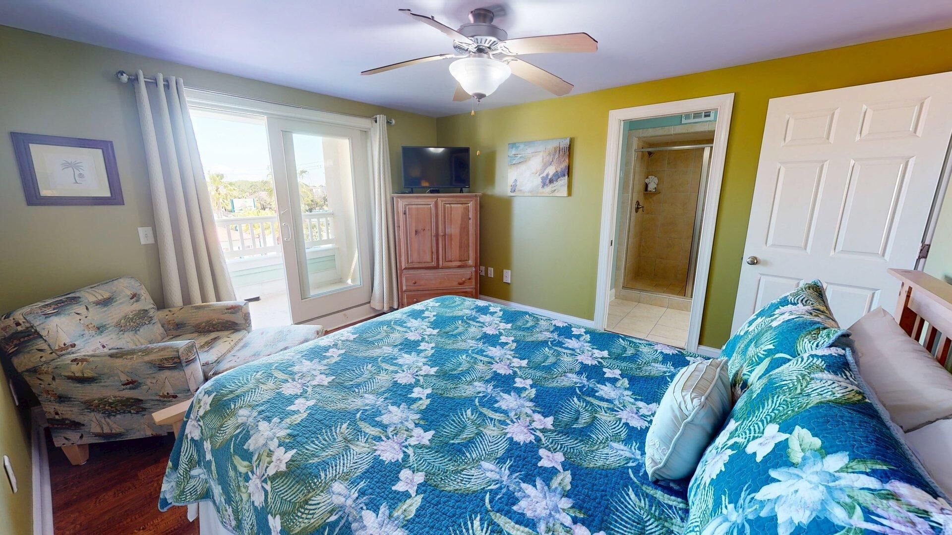 Une chambre à coucher comprenant un lit, une chaise, une armoire, une douche et un téléviseur.