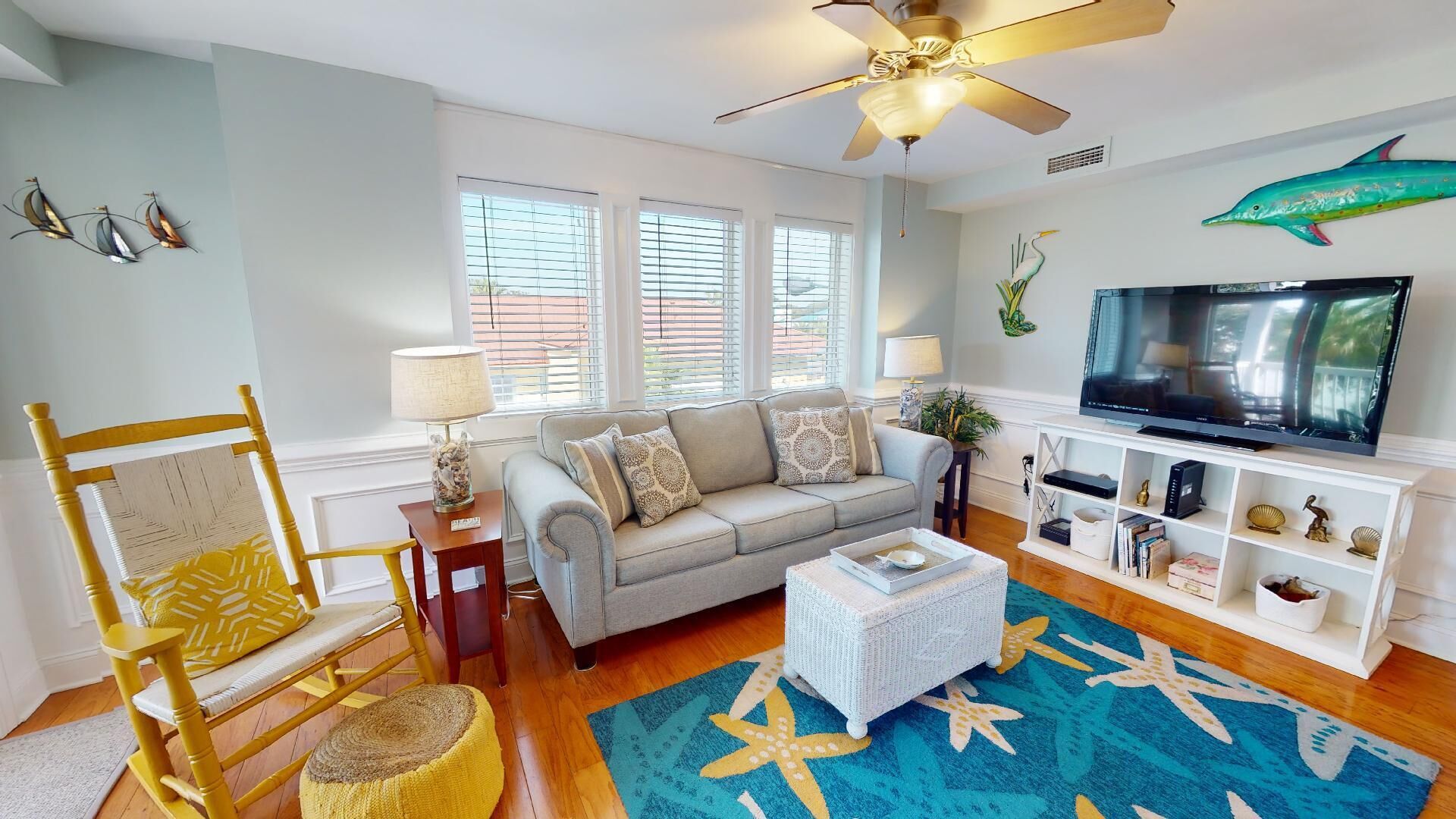A living room with a sofa, coffee table, TV, and decorative items.