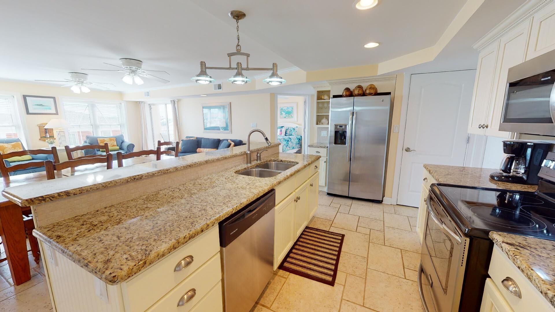 A modern kitchen with granite countertops, stainless steel appliances, and a central island with a sink.
