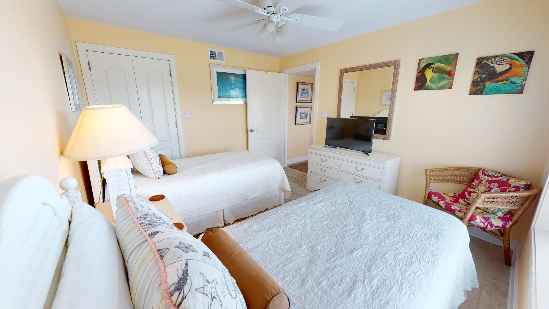 A bedroom with a bed, a dresser, a television, and a chair.