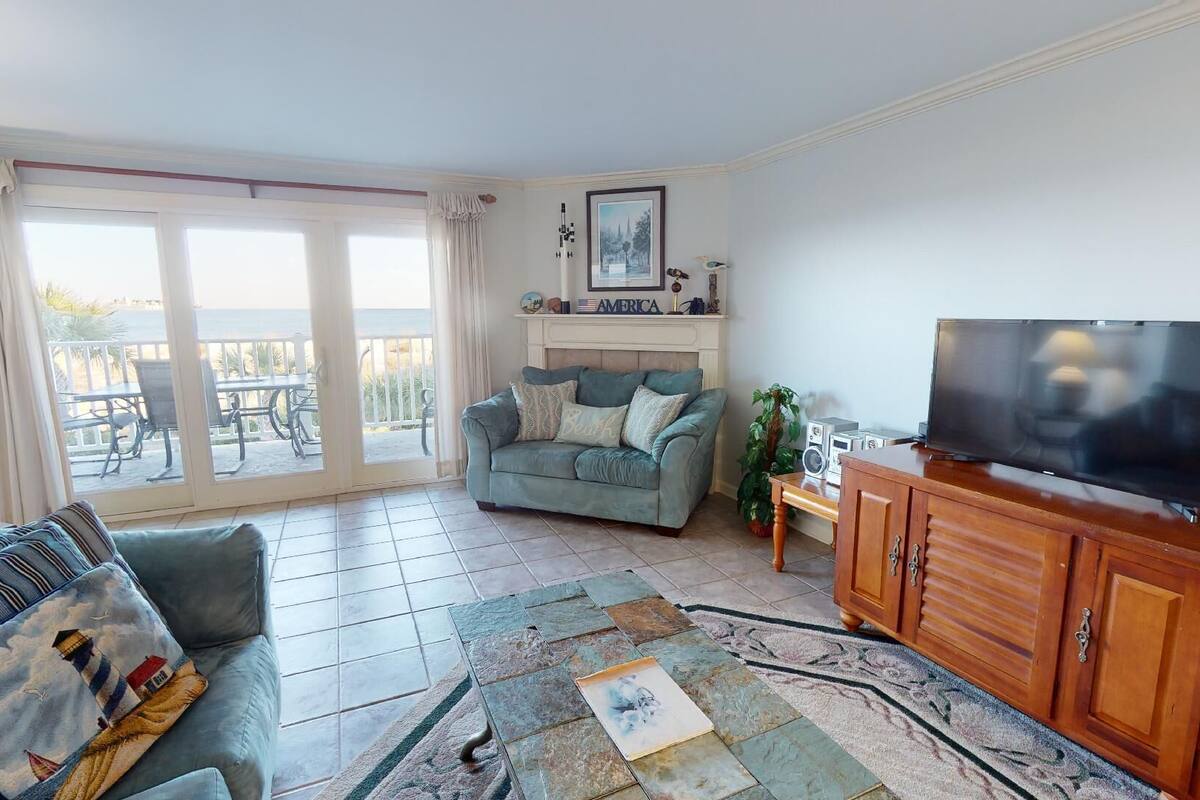 Una sala de estar con sofá, televisor y chimenea.