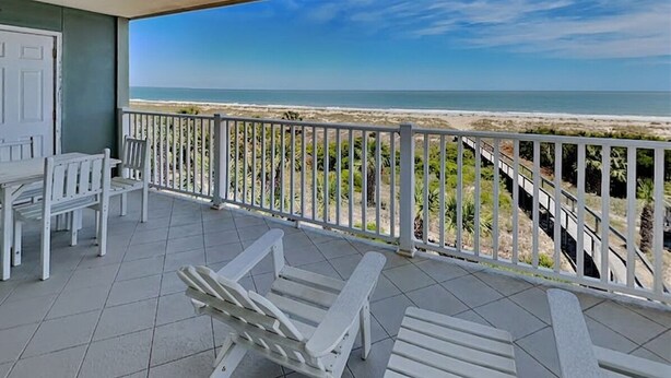 A balcony with white chairs and a view of the beach. - Fort Screven Villas Tybee Vacation Rentals (Tybee Island)