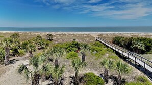 A coastal landscape with a paved walkway, sandy terrain, and sparse vegetation. - Fort Screven Villas Tybee Vacation Rentals (Tybee Island)