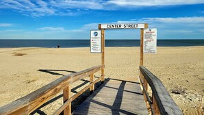 A wooden boardwalk leading to a beach with signs indicating beach rules and warning flags. - Gull Reef 614 Tybee Vacation Rentals (Tybee Island)