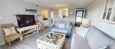 A living room with a television, sofas, and a coffee table.