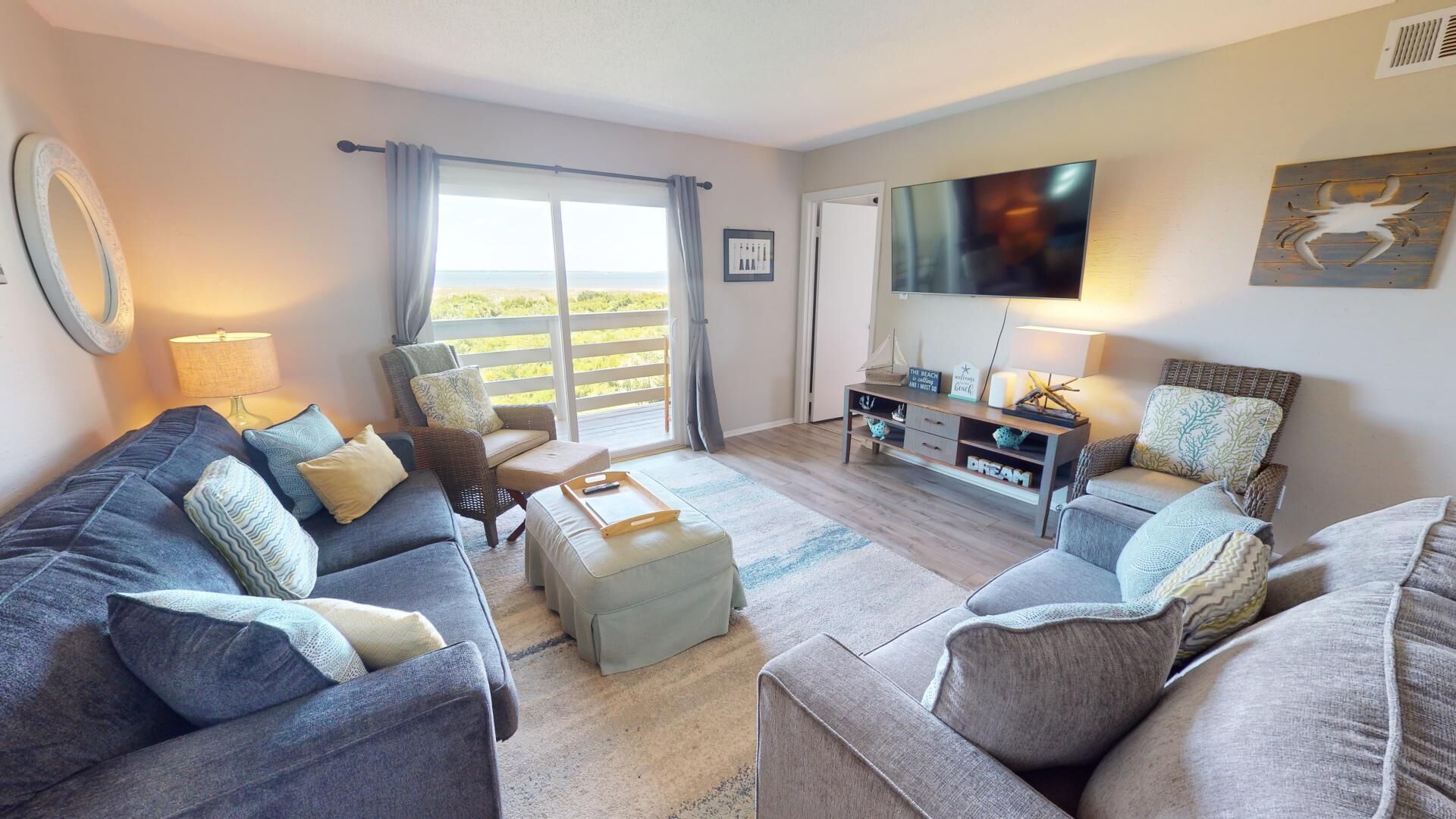 A living room with a sofa set, a coffee table, a TV, and a view of the outdoors.